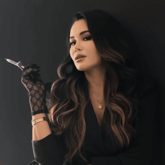 Allie posing in all black with syringe of filler
